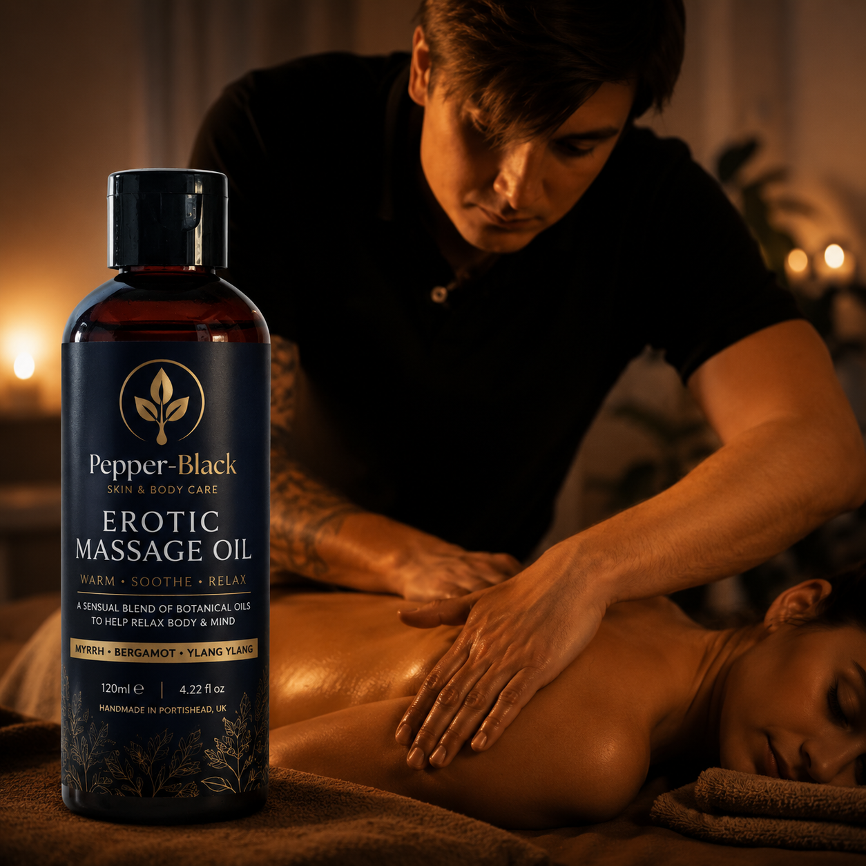 A bottle of Pepper-Black Erotic Massage Oil is shown in the foreground against a warm, dimly lit background of a man massaging a woman's back.