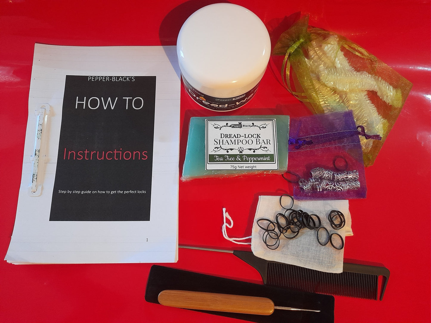 Hair care product set with shampoo bar, comb, and instructions on a red surface