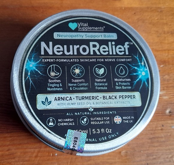 A round metal tin of Vital Supplements NeuroRelief Neuropathy Support Balm, featuring a black label with blue lightning graphics and text for 'Arnica, Turmeric, Black Pepper', placed on a wooden surface.
