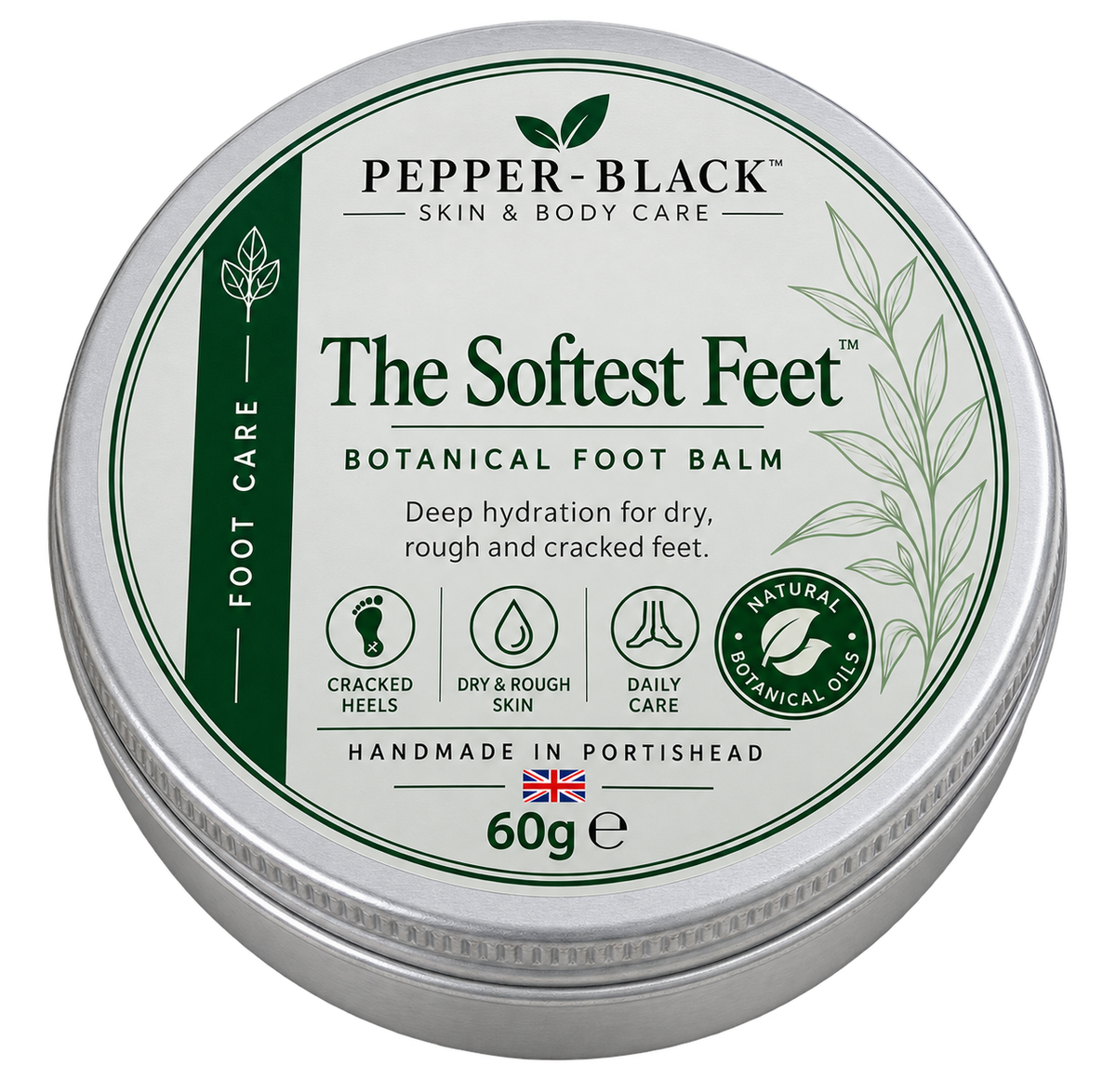 A round silver metal tin of Pepper-Black 'The Softest Feet' Botanical Foot Balm, featuring a white and green label with product details and icons, on a plain white background.